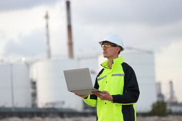 petrochemical engineer working with laptops outside the oil and gas refinery plant industry factory...