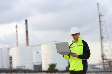 petrochemical engineer working with laptops outside the oil and gas refinery plant industry factory...
