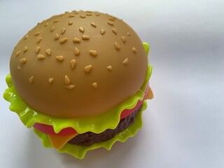 Plastic hamburger contain of vegetables, meat, tomatoes and buns, on white background, isolation,...