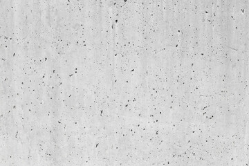 New exposed concrete wall displaying distinct perforations resulting from the gradual evaporation of the mixing water during the curing process