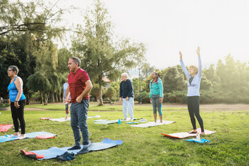 Senior sport people exercising during yoga workout class outdoor at park city. Fitness joyful...