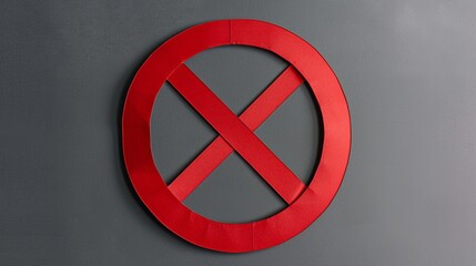 Fototapeta premium A red prohibition sign cut out of paper against a gray background.