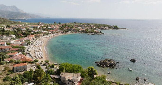 A breathtaking aerial perspective of Stoupa Kalogria Beach in Kardamili, Greece. The image captures the tranquil blue waters, sandy shore.