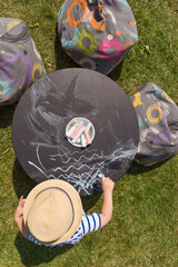 Top view on cute little toddler boy sitting at the chalk board table and drawing sea. Outdoors...