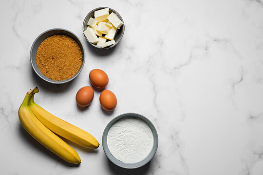 Baking banana bread, ingredients on marble background