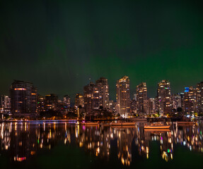City skyline at night and glowing Aurora Borealis. Vancouver. BC. Canada