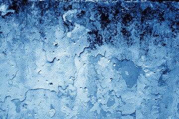 Grungy dirty plaster wall with peeling paint. Blue color style.