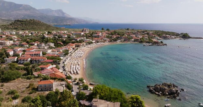 A breathtaking aerial perspective of Stoupa Kalogria Beach in Kardamili, Greece. The image captures the tranquil blue waters, sandy shore.