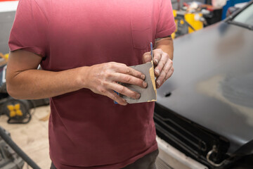 Close-Up of Mechanic Applying Body Filler to Car