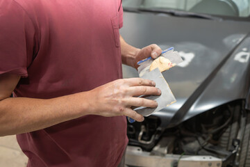 Mechanic Preparing Body Filler in Auto Repair Shop