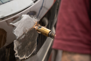 Close-Up of Electric Dent Puller Repairing Car Door