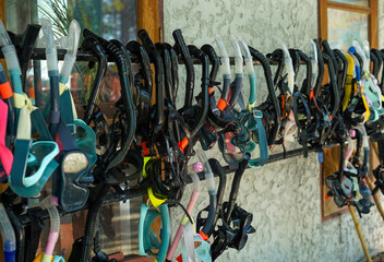 Group of rental snorkels, goggle and diving gears hanging to dry at a shop or service for tourist...