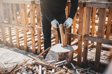 Axe cutting wood block. Concept of preparation firewood for kindling and heating the house. Man...