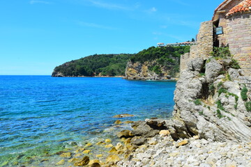 Budva, Montenegro - May 04, 2024 : The Old Town Fortress in Budva. A stone wall on the shore of the Adriatic Sea in Montenegro. Horizontal. On a hot, sunny, spring afternoon.