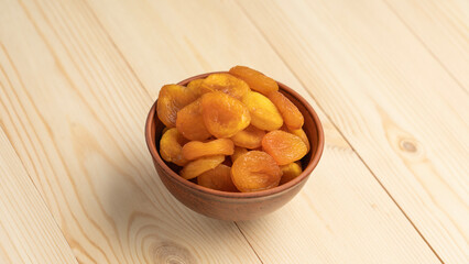 Dried Fruits wooden table. Dried apricots in a clay cup on a wooden background