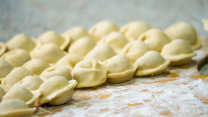 Homemade dumplings close-up. handmade dumplings on a wooden board, selective focus, tinted image, traditional Russian dish,