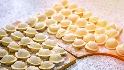 Homemade dumplings close-up. handmade dumplings on a wooden board, selective focus, tinted image, traditional Russian dish,