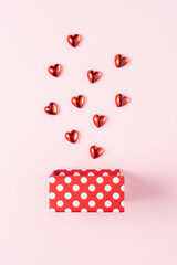 Gift box with hearts on pink background. Minimal love concept.