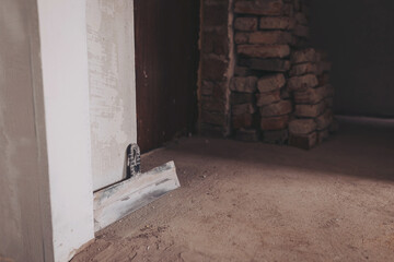 workplace. working with spackling. Damaged wall repair. putty knife on gray grunge cement wall background. spatula for repair and construction. building concept. work tool and equipment.