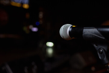 Microphone on stand before crowd, part of public address system at event