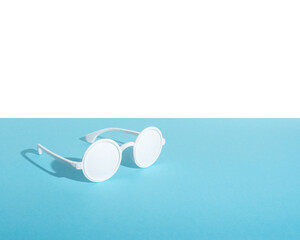 White sunglasses on blue background. Creative minimal concept.