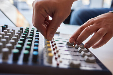 Hands playing buttons on an electronic keyboard mixer