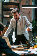Angry office boss shouting, arguing and threatening his employee. Anger management concept.