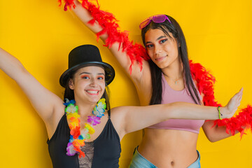 two beautiful young latinas, raising their hands, dressed in party or carnival clothing