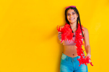 young brunette latina woman, laughing out loud while dancing with a strip of red feathers, dressed...