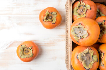 Delicious fresh persimmon fruits on wooden table.