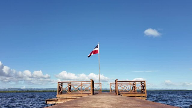 A Jetty by the Sea on Which the Flag of the Dominican Republic is Waving.