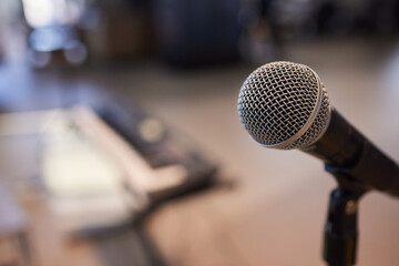 Microphone on stand before crowd, part of public address system at event