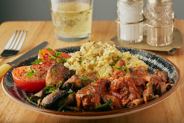 Cooked breakfast with scrambled eggs,fish,mushrooms and tomato.