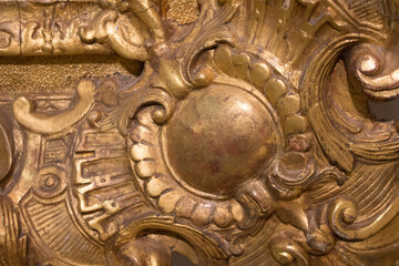 Fragment of an ancient gold picture frame, wood carving close-up. An expensive antique frame.