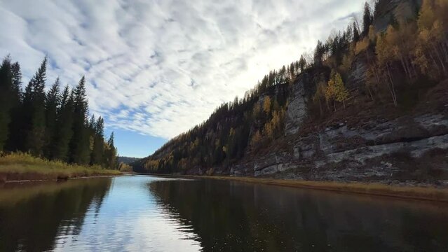 Perm Region, Usva - September 2023. Boat trip to the Usva pillars. A view of the flashing autumn trees and the lapping of the waves from a boat sailing down the river.4К