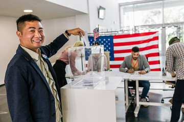 Asian voter in America placing ballot in ballot box polling place.