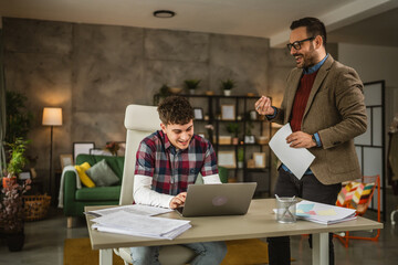 Adult professor mentor show lesson on laptop to young student at home