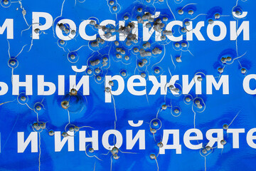 A fragment of an information sign in Russian, shot by hooligans with a shotgun shot. Russia