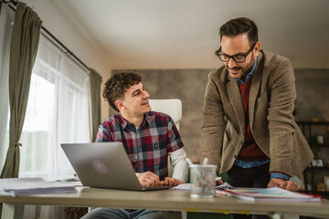 Obraz premium Adult professor mentor show lesson on laptop to young student at home