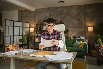 Young caucasian man with eyeglasses sit and study for exam at home