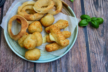 Selection of fast food snack. italian cheese breaded Mozzarella Sticks, Jalapeno Cheese nuggets, Onion Rings and mayo sauce.Italian street junk food