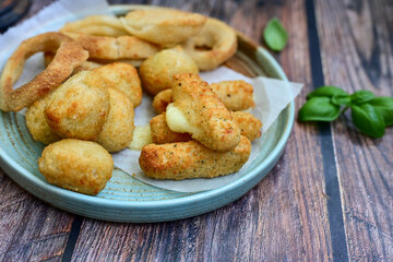 Selection of fast food snack. italian cheese breaded Mozzarella Sticks, Jalapeno Cheese nuggets, Onion Rings and mayo sauce.Italian street junk food