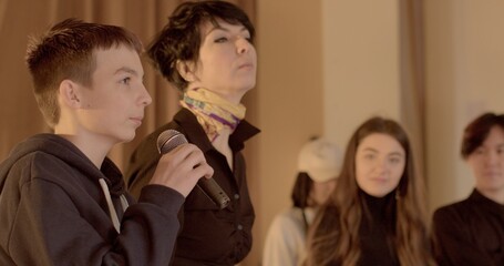 Teenage student speaks into the microphone during school debate. 7th grader confidently expresses...