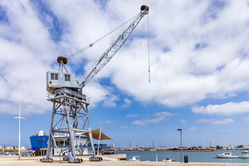 Fototapeta premium Old port crane with storks nests at Portimao harbour, algarve, Portugal
