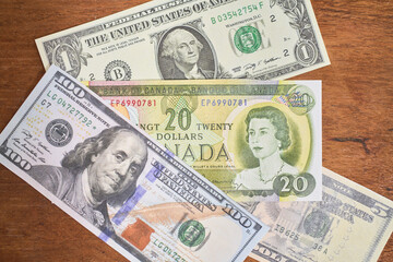 Comparison of dollar bill with canadian dollar, concept of inflation or abundance