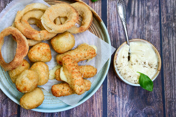 Selection of fast food snack. italian cheese breaded Mozzarella Sticks, Jalapeno Cheese nuggets, Onion Rings and mayo sauce.Italian street junk food