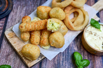Selection of fast food snack. italian cheese breaded Mozzarella Sticks, Jalapeno Cheese nuggets, Onion Rings and mayo sauce.Italian street junk food
