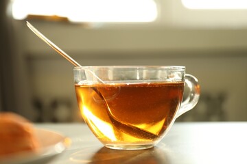 Tasty tea with sugar and spoon on table, closeup