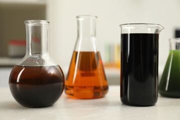 Flasks and beaker with different types of crude oil on light table