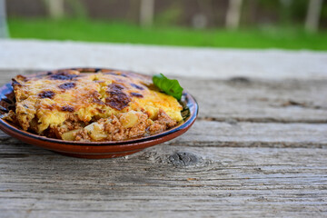 Bulgarian traditional moussaka Potato and minced meat  Casserole  with   parmesan cheese and garlic on wooden rustic bakcground.  